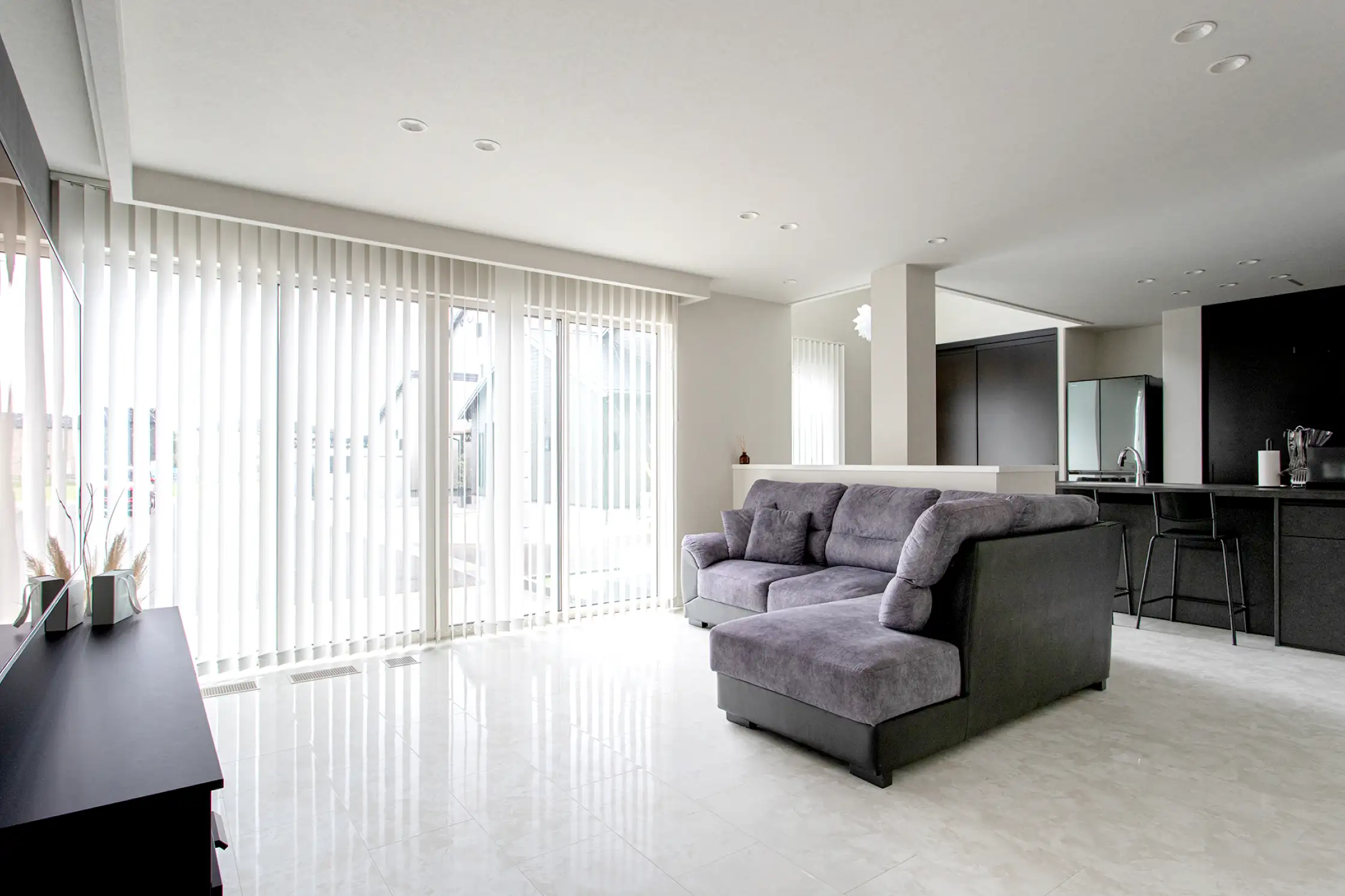 バーチカルブラインドがある白とグレーで統一されたスタイリッシュなリビング