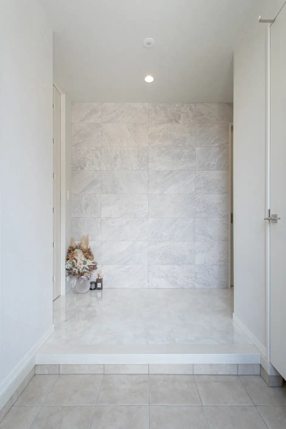 白とグレーで統一された優しい色合いの玄関