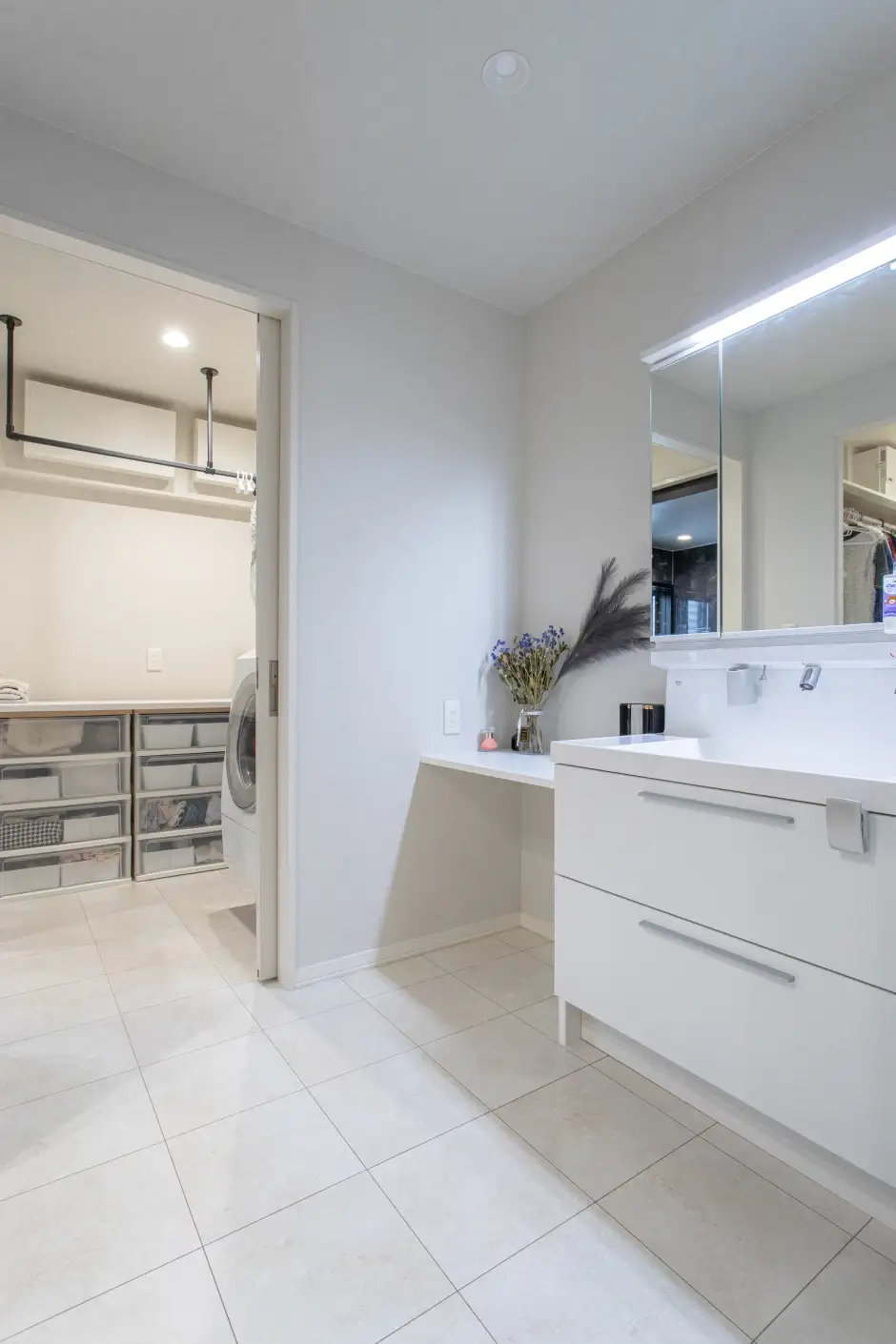 洗面台とカウンターがある洗面室と奥につながる脱衣室