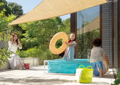 テラスで水遊びをする子供たちと見守る母親