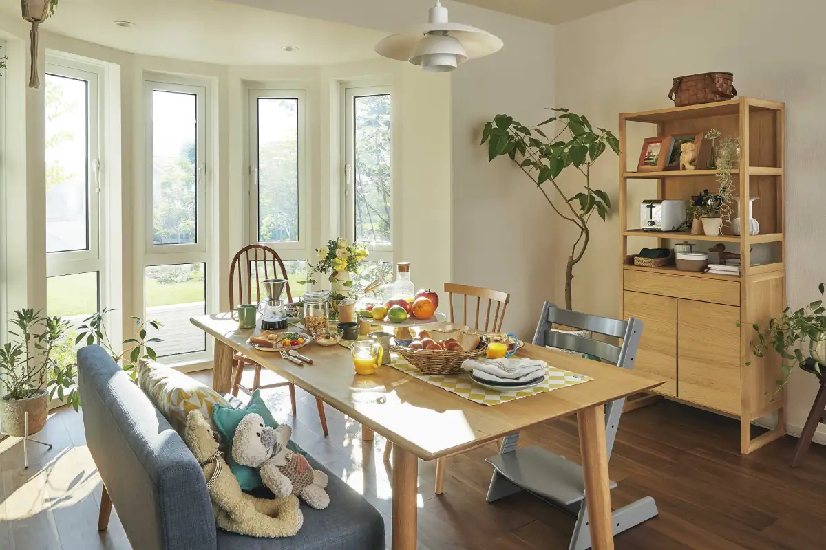 ボウウインドウのあるスペースにダイニングテーブルを置いた、家族が集まる空間