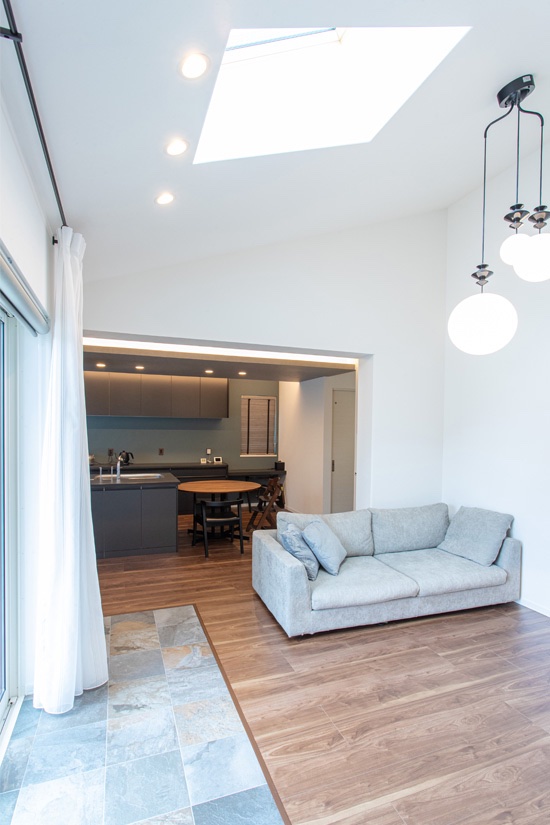 一角のタイルテラスが映える、天井高のある開放的なリビング