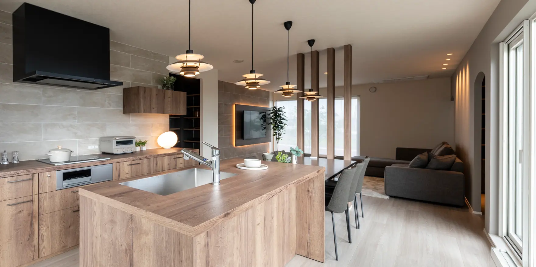 ダイニングテーブルと一直線につなげた木目調のキッチン