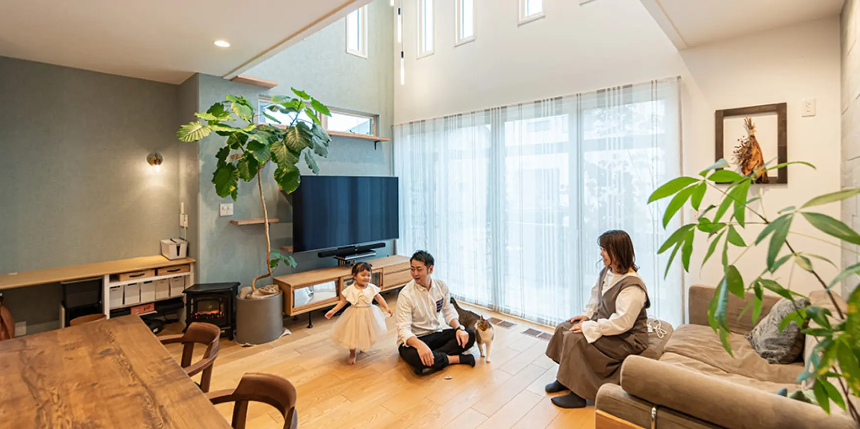 吹き抜けのあるリビングでくつろぐ家族の様子