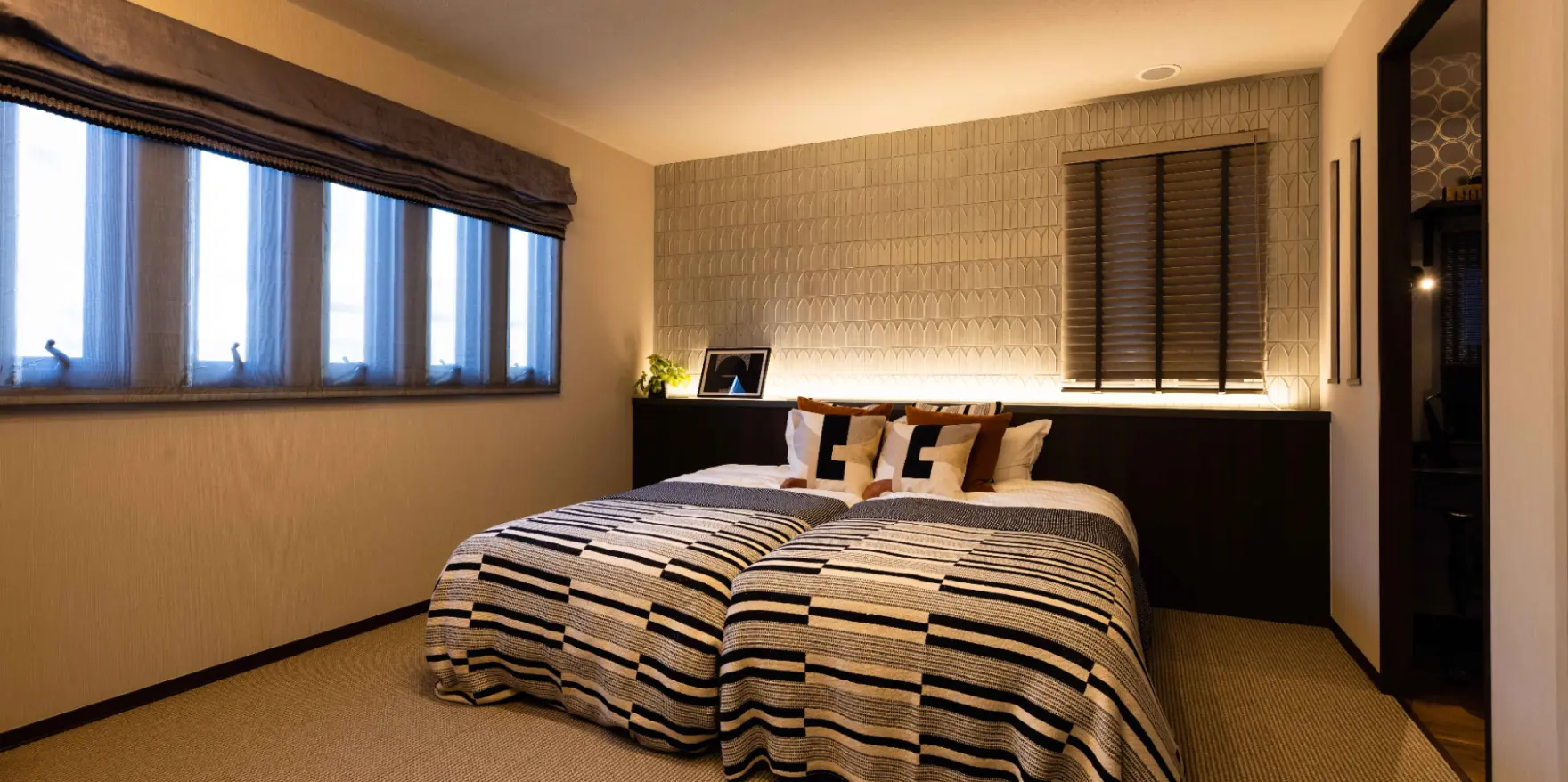 ヘッドボードに間接照明を設けた落ち着きのある寝室