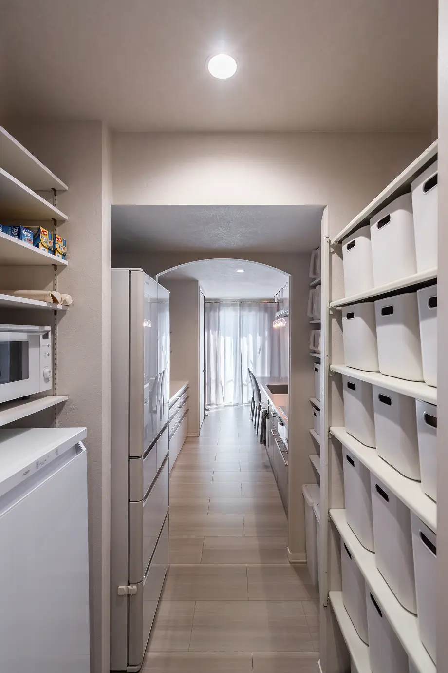 収納カゴで整頓されたウォークスルー型のパントリー