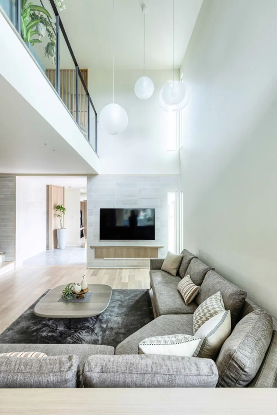 ホワイト基調でまとめられた吹き抜けのあるリビング