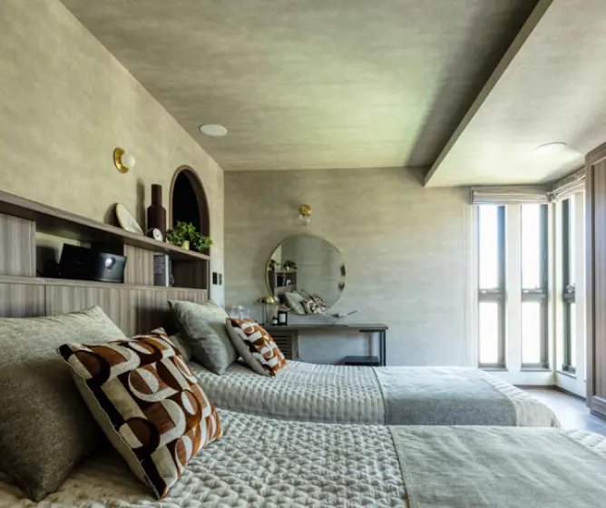 大きな丸鏡のついたパウダーコーナーを設けた寝室