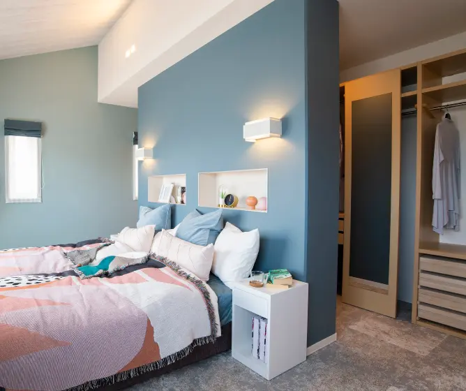 ウォークインクローゼットに隣接した勾配天井の寝室