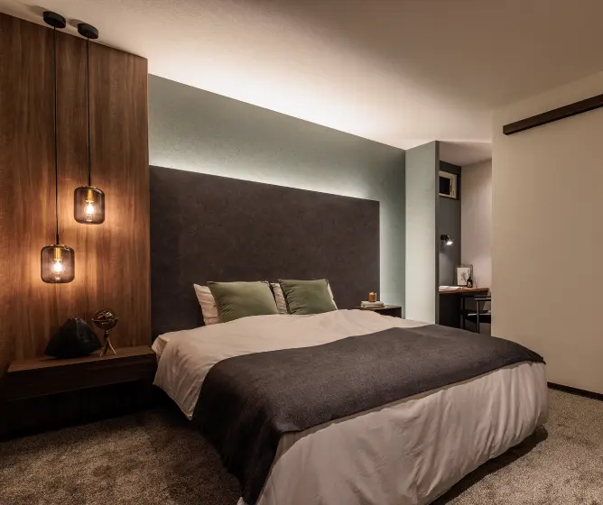 コーブ照明とペンダントライトのある寝室