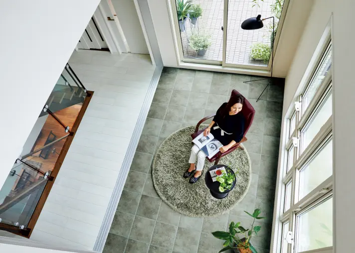 大きな吹き抜けのある空間でくつろぐ女性