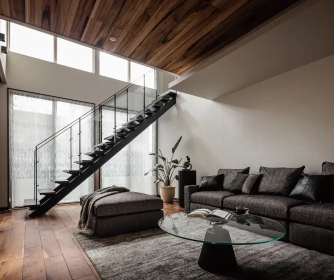 大きな窓と吹き抜けの前に階段があるリビング