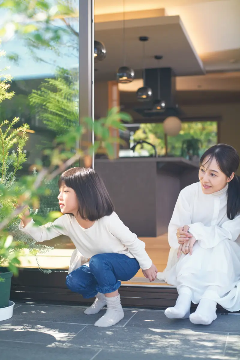 日当たりの良いバルコニーで​触れ合う親子