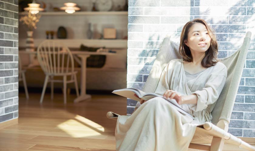 リビングの椅子に座って、外を眺めている女性